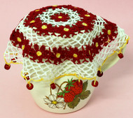 Crocheted jug cover featuring rings of daisy flowers.