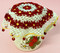 Crocheted jug cover featuring rings of daisy flowers, shown on jug.