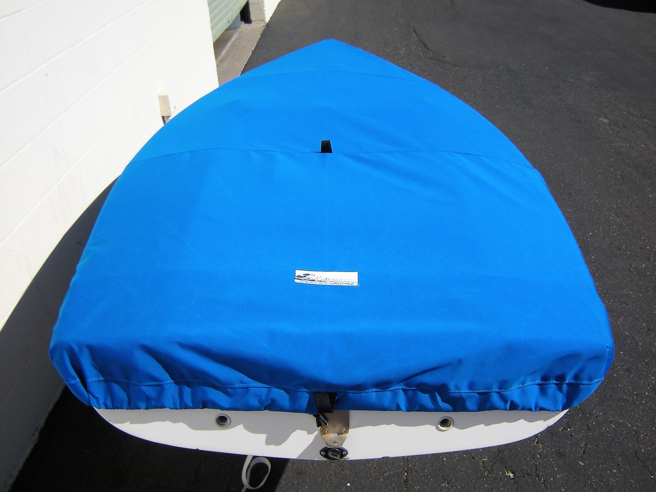 Flying Junior sailboat Top Cover by SLO Sail and Canvas. 1/4" shockcord is built into cover to secure your cover tightly around the boat's rubrail. Web Loops allow you to “tent” your cover up to prevent pooling of water. 
