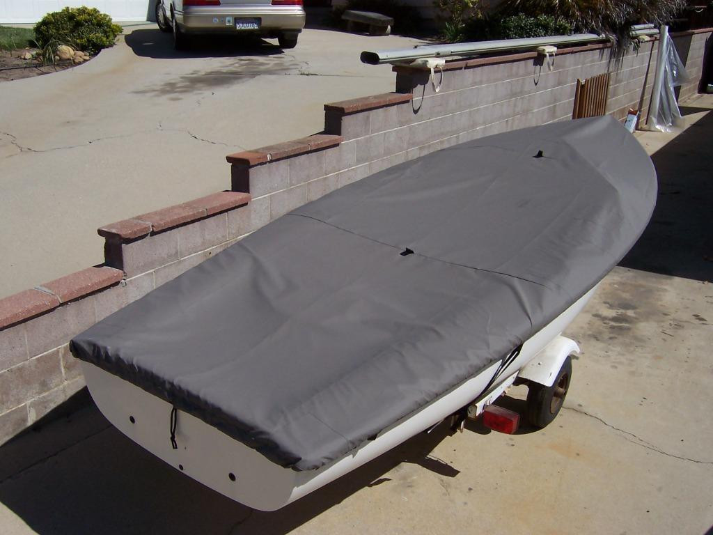 Sailboat Top Deck Cover by SLO Sail and Canvas. 1/4" shockcord is built into cover to secure your cover tightly around the boat's rubrail. Web Loops allow you to “tent” your cover up to prevent pooling of water. 
