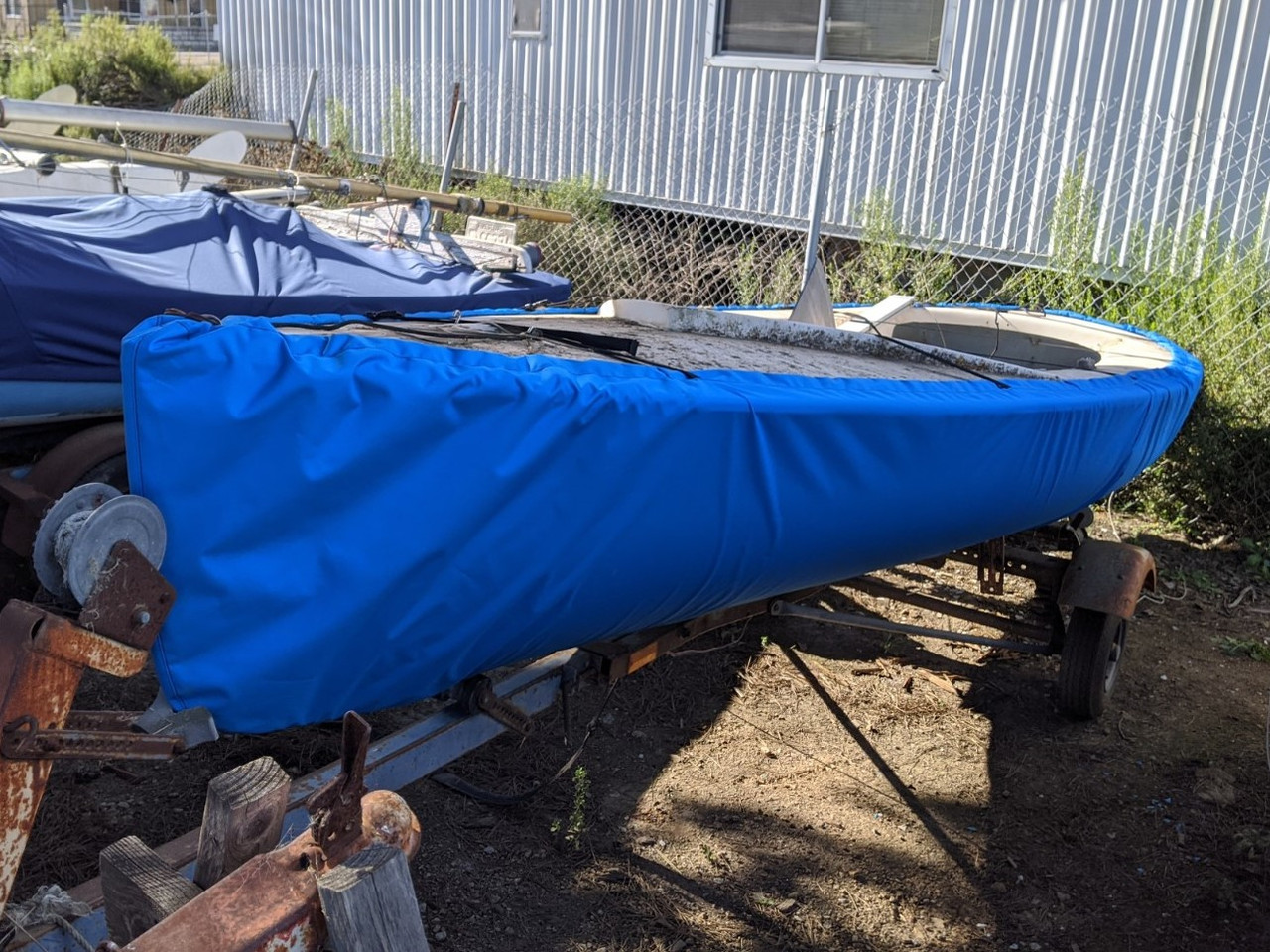 Finn Sailboat Hull Cover made in America by skilled artisans at SLO Sail and Canvas. 1/4" shockcord is built into cover to secure your cover tightly around the boat's rubrail. 
