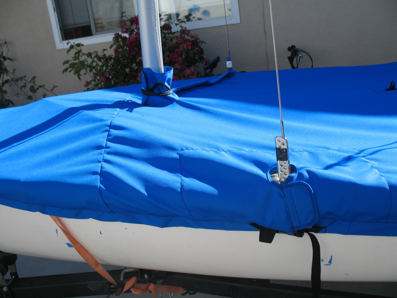 Flying Junior Mast Up Flat Mooring Cover by SLO Sail and Canvas. A mast collar and perfectly placed shroud cutouts fit tightly around your boat’s rigging. 
