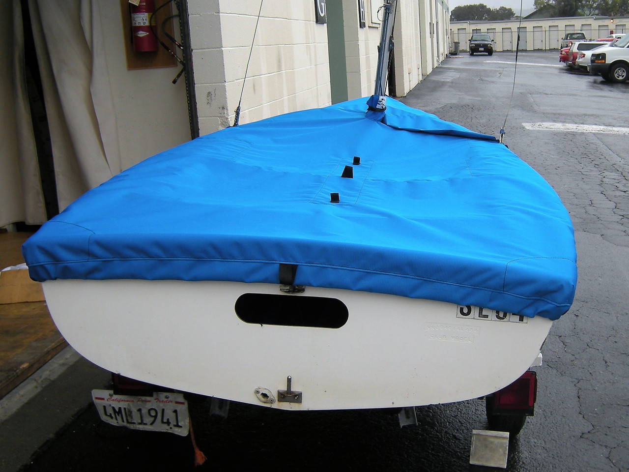 Flying Junior Mast Up Flat Mooring Cover by SLO Sail and Canvas. 1/4" shockcord is built into cover to secure your cover tightly around the boat's rubrail. Web Loops allow you to “tent” your cover up to prevent pooling of water. 
