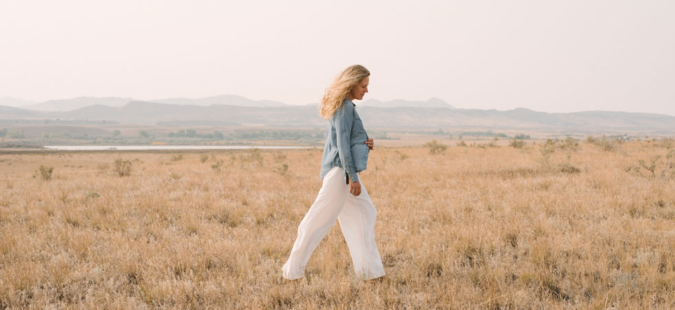 The creator of Queen of the Meadow walking in a field on our family property.