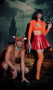 Mystery Pup costume includes sleeveless fleece short jumpsuit with attached dog hood featuring ears, snout and nose, attached stuffed tail and front zipper closure. Collar with detachable chain leash also included. Two piece set.