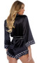 Satin romper features Playboy bunny head logo print trim, contrast piping, patch pocket, collar, three quarter length sleeves with cuffs, and waist sash with tie closure.