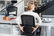 Person adjusting the lumbar support on a HÅG SoFi ergonomic chair while seated at a desk