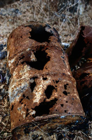 A corroded hazardous waste drum in a hazardous waste site.