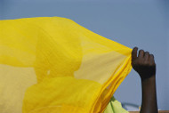 Back to the camera, a person holds up a yellow piece of fabric