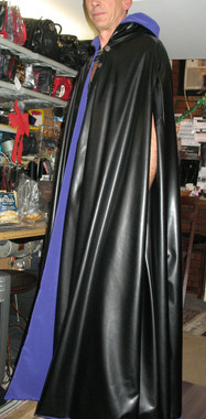 Reversible Pleather and Peachskin Cape with Working Hood, button with chain closures in front, and armholes. Model is 6'4" tall.
