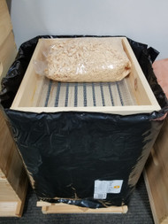Quilt Box w/ pine shavings shown on top of a hive that's wrapped with a Bee Cozy. Bee Cozy sold separately.