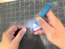 Hands demonstrating the blue lighted seam ripper by the Gypsy Quilter.