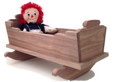 Large enough to hold a favorite baby doll, stuffed animal, or a family of little ones, this detailed and durable cradle from yesterday will be enjoyed today and then saved for tomorrow. Crafted out of solid walnut, the doll cradle is 21" long x 14" wide x 11" high. Pictured with a Raggedy Ann doll for display purpose only.