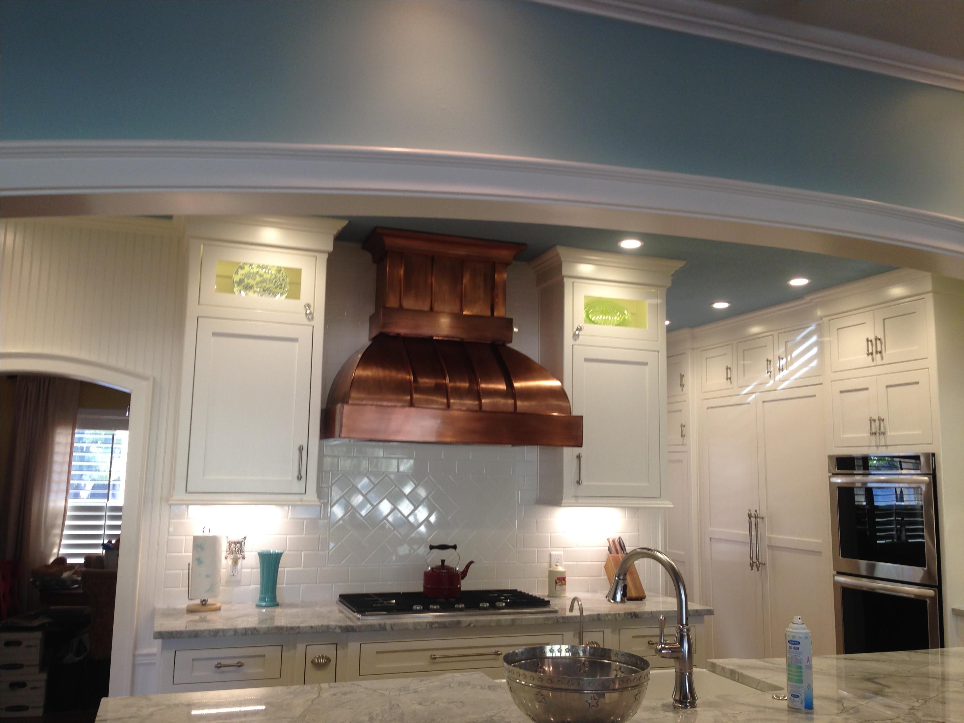 an under cabinet style copper range hood in a kitchen
