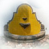 Front view of the classic colonial cantera wall fountain with round base and handmade tiles.