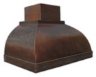 Side view of a custom copper range hood with intricate hammered detailing