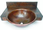 round copper bathroom sink with a counter
