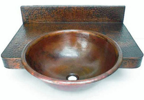round copper bathroom sink with a counter