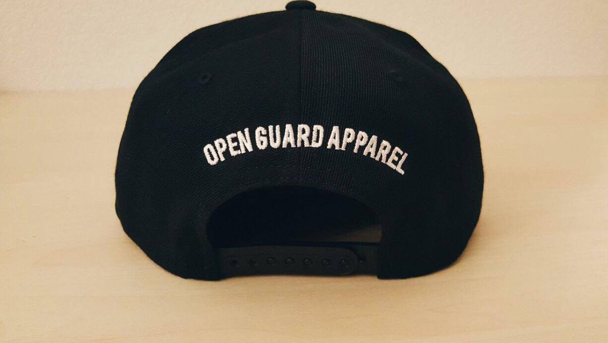 Back of OGA Open Guard Apparel Jiu Jitsu vs The World Snapback hat. Black hat with white embroidery in the background of his picture..  Jiu Jitsu vs the world series from Open guard apparel. 

Enjoy Free Shipping on all products storewide today. 