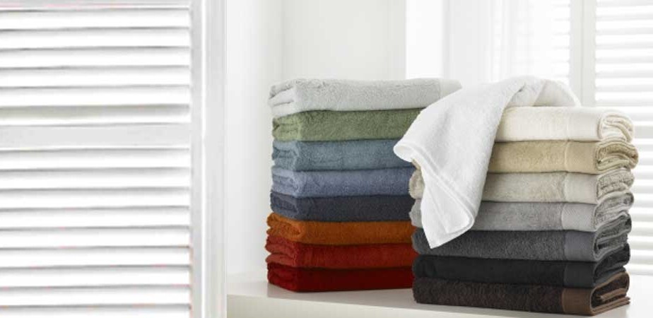 A plush stack of premium Baksana bamboo and cotton blend towels in earthy neutral colors, showcasing the thick 700 GSM texture.