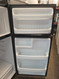 AMERICANA BY GE 16 CUBIC FOOT REFRIGERATOR TOP FREEZER WIRE SHELVES 1 LARGE CRISPER DRAWER FULL WIDTH WIRE SHELF IN FREEZER BLACK LOCATED IN OUR PORTLAND OREGON SKU 23358
