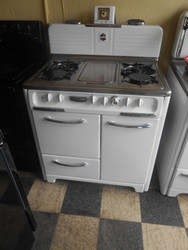 VINTAGE 36 INCH WEDGEWOOD GAS RANGE WITH 4 BURNERS AND CENTER GRIDDLE SIDE HEATER OVEN ON LEFT SIDE AND BOTTOM BROILER WHITE WITH CHROME TOP AND HANDLES WHITE KNOBS LOCATED IN OUR PORTLAND OREGON APPLIANCE STORE