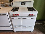 VINTAGE O'KEEFE & MERRITT 35 INCH 4 BURNER GAS FREE STANDING GAS RANGE SINGLE OVEN WITH BROILER DRAWER ON BOTTOM SIDE STORAGE COMPARTMENT WHITE WITH RED KNOBS AND CHROME HANDLES LOCATED IN OUR PORTLAND OREGON APPLIANCE STORE SKU 17206