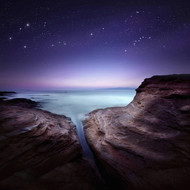 Two Large Rocks In A Sea Against Starry Sky