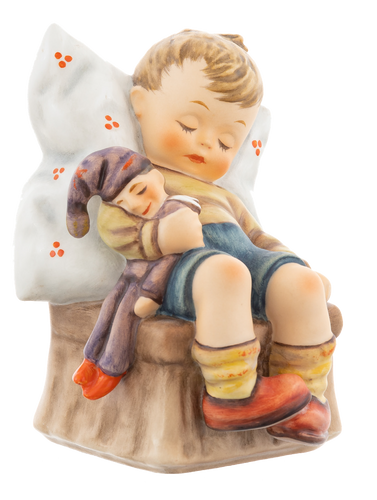 M.I. Hummel 'Just Dozing' (HUM 451) showing a boy asleep in a chair holding a doll.
A close-up of the boy's peaceful facial expression and the hand-painted details of the wooden-style chair.