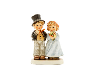 M.I. Hummel figurine HUM 2003 Dearly Beloved featuring a bride in a white gown and a groom in a top hat and tails, handcrafted in Germany.