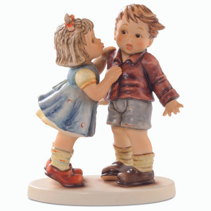 First Kiss HUM 2337 M.I. Hummel figurine of a young girl kissing a surprised boy on the cheek. Close-up of the girl on her tippy toes from the M.I. Hummel First Kiss figurine.