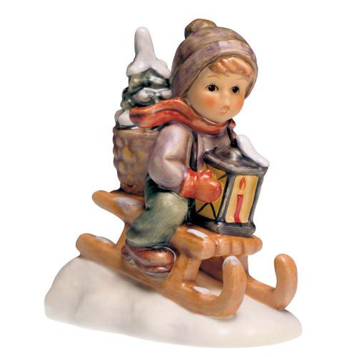 Ride Into Christmas HUM 396 M.I. Hummel figurine of a boy on a sled carrying a Christmas tree and a lantern. Close-up of the hand-painted evergreen tree and lantern on the M.I. Hummel Ride Into Christmas figurine.