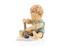 M.I. Hummel figurine HUM 2201 Baby’s First Drawing featuring a toddler in blue overalls holding a pencil and his first sketch, handcrafted in Germany.