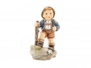 M.I. Hummel 'Trail Blazer' figurine HUM 2045 showing a young boy hiker with a backpack and walking stick.
Detail of the hand-painted edelweiss flower and blue hat feather on the Trail Blazer Hummel.