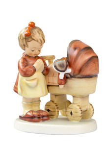 M.I. Hummel figurine HUM 67 "Doll Mother" of a girl praying over a doll in a carriage.