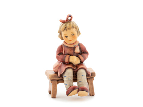 M.I. Hummel figurine HUM 2410 "Charlotte" girl with a bow sitting on a stool.