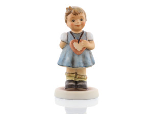 M.I. Hummel My Heart’s Desire figurine HUM 2102/A featuring a young Bavarian girl in a traditional blue Dirndl dress with a heart.