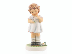 M.I. Hummel figurine HUM 2437 Margarete featuring a young girl braiding a daisy wreath into her hair, authentically handcrafted in Germany.