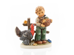 M.I. Hummel figurine HUM 2426 Harvest Thanksgiving featuring a young boy celebrating the autumn harvest, authentically handcrafted in Germany.