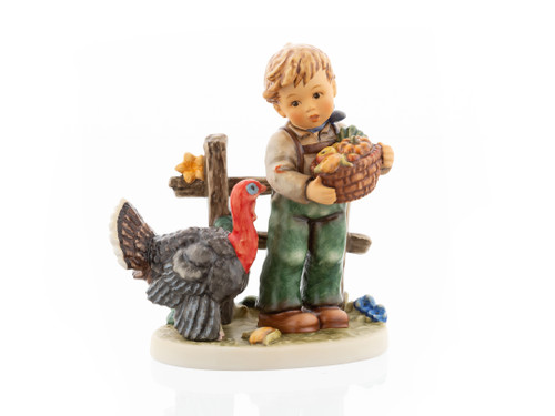 M.I. Hummel figurine HUM 2426 Harvest Thanksgiving featuring a young boy celebrating the autumn harvest, authentically handcrafted in Germany.