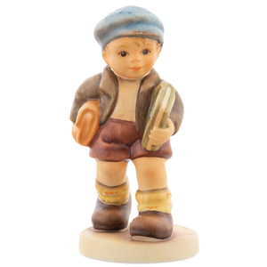 M.I. Hummel 'School Days' (HUM 2220) featuring a small boy in a light blue cap and matching school suit. A close-up of the boy's enthusiastic expression and the delicate hand-painted blue ensemble.