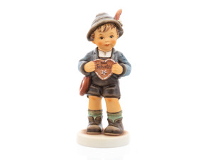M.I. Hummel figurine HUM 2447 We Belong Together featuring a boy in traditional Lederhosen holding a gingerbread heart that says "Darling."