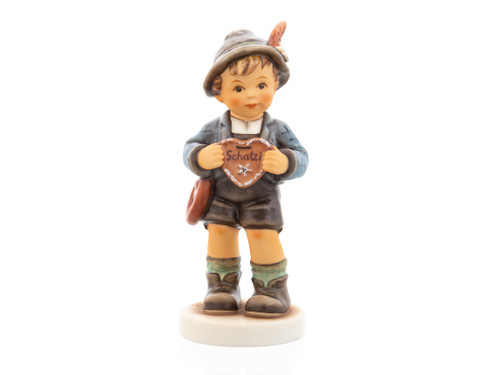M.I. Hummel figurine HUM 2447 We Belong Together featuring a boy in traditional Lederhosen holding a gingerbread heart that says "Darling."
