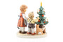 M.I. Hummel figurine HUM 2398 Contemplative Time featuring a brother and sister admiring a decorated Christmas tree with a hidden cat, handcrafted in Germany.