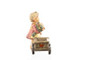 Close-up of the hand-painted flowers and wooden wagon on the M.I. Hummel 2013 figurine.