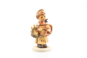 M.I. Hummel Pretzel Girl HUM 2004 porcelain figurine of a young girl holding a basket of pretzels.