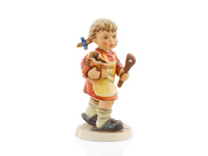 M.I. Hummel Mixing the Cake HUM 2167 porcelain figurine of a girl with braids, red dress, and wooden spoon.