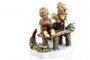 Detailed view of the hand-painted porcelain sailboat and rustic dock from the Hummel Little Captains anniversary release.
