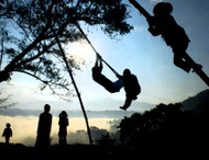 Nepal

An important part of Nepal’s celebration of the Hindu autumn festival of Dashain are traditional swings, called “pings.” A frame is made of 4 bamboo shafts set into holes in the ground, bent inward, and tied at the apex with sturdy natural jute rope—a traditional technology unchanged for centuries. The seat is just a loop of rope or a simple wooden board, and standing to swing is more common that sitting. With heights exceeding 20 feet, the swinging arc is so long its’s easy for kids to imagine they’re flying.

Photo © 2009 Scott Faiia