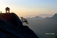 Mount Huashan, China:  With most of my belongings carefully wrapped in brown paper, tied with twine, sealed with a wax stamp, and mailed home at the end of my service in the Russian Far East program, I traveled lightly by train to Irkutsk, south through Mongolia, and into China. In Beijing, a fellow traveler told me about the Taoist holy mountain called Hua Shan, long a place of retreat for hermits and the devout who have found “the way.” Another train ride later, to Central China’s Shaanxi Province, I began the long hike up the mountain around midnight so that I would arrive at the summit in time to see this amazing sunrise.

Near the top, I helped a seller yoked with produce baskets make the final ascent. He later recognized me when I passed him on my return, smiled, and handed me a beautiful tomato.

Photo © 1997 Michael J. Kresko